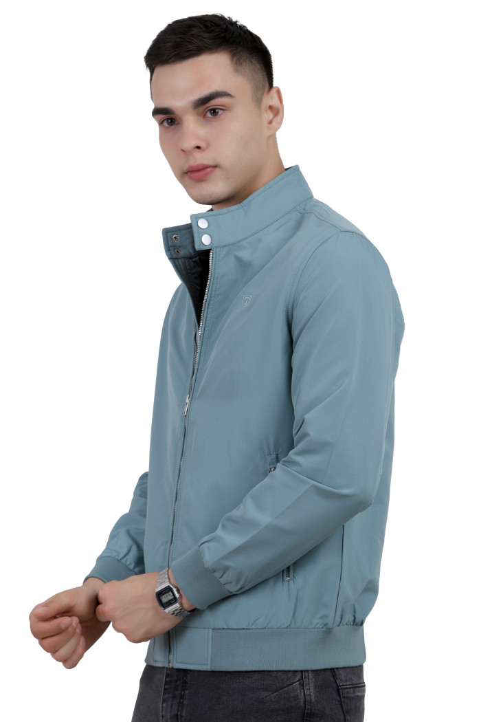 A left pose of a man wearing an Aqua Blue Finish Lightweight Jacket with high neck collar, zipper closure,e and pocket in hand designed for casual winter layering and comfort.